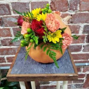 ceramic pumpkin shaped container with flowers for a centerpiece